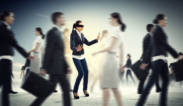 Image of businesswoman in blindfold walking among group of people