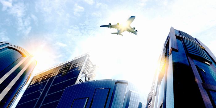 Plane flying above skyscrapers. Business travel concept