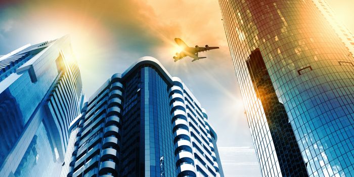 Plane flying above skyscrapers. Business travel concept