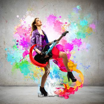 Young attractive rock girl playing the electric guitar