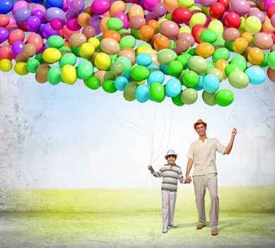 Image of father and son holding bunch of colorful balloons