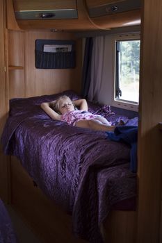 A girl sleeping in a bunk bed inside a moving trailer