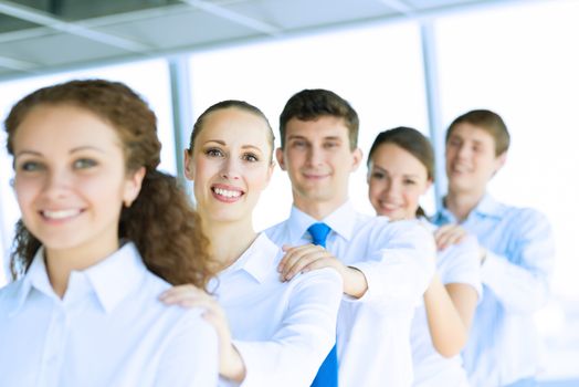 portrait of a young business woman standing in line with colleagues, concept of teamwork