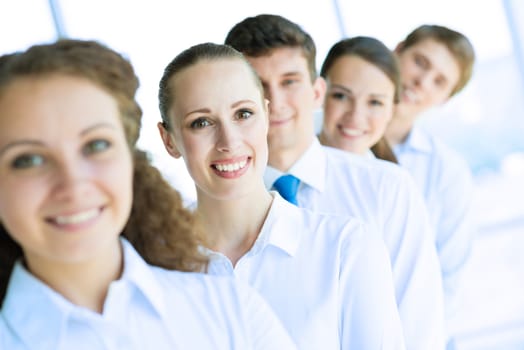 portrait of a young business woman standing in line with colleagues, concept of teamwork