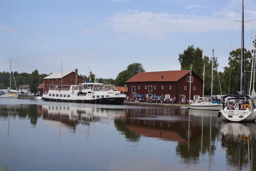 A harbor on the Gota Canal in Sweden with a passenger ship arriving for a stop