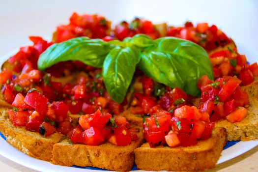 Crusty bruschetta with fresh diced tomatoes, garlic and basil is a popular Italian antipasto served in most retaurants
