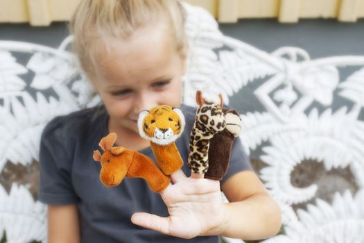 A little girl playing games with her finger puppets. Short depth of field, sof focus