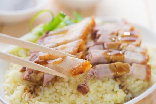 Siu Yuk - Chinese roasted pork served with soy and hoisin sauce. Hong Kong cuisine. Close up on meat and chopsticks.