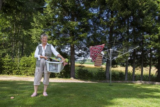 Senior pensioner holding a laundry basket full of clean clothes