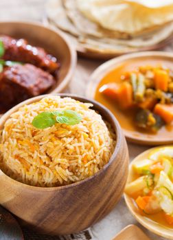 Indian meal biryani rice, chicken curry, acar vegetable, roti chapatti and papadom.