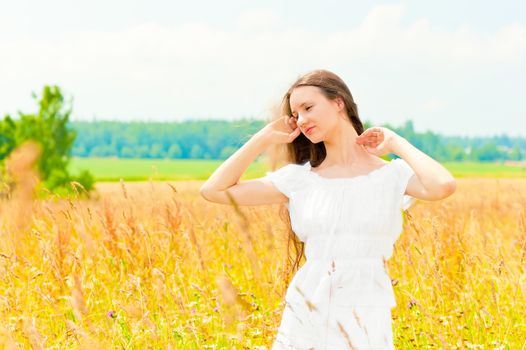 beautiful young Russian girl in a field with gold ears of wheat