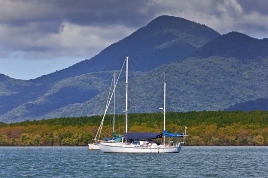 Luxury yacht moored off the Australian coast with a mountain peak in the background