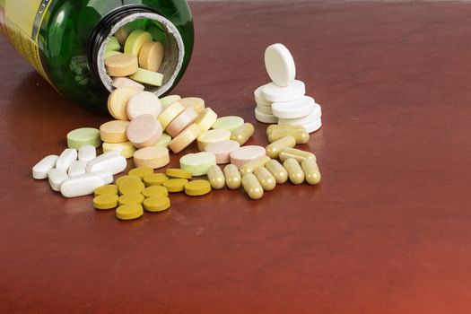 A bottle surrounded by different pills and vitamins.