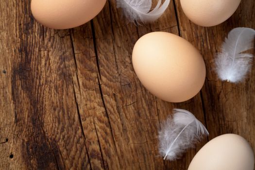 Fresh eggs on wooden table background with copy space. Top view