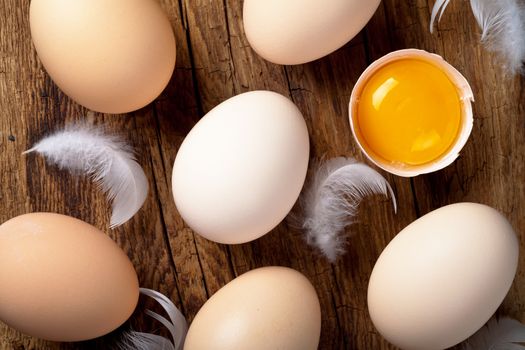 Eggs, whole and broken, on wooden background. Top view