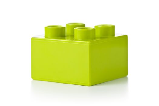 Plastic toy block, green color, on white background