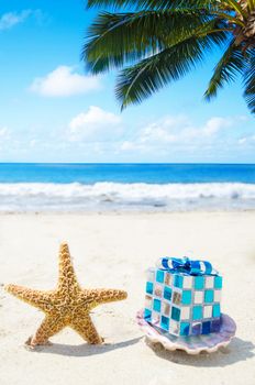 Starfish and seashell with Christmas decoration on sandy beach in sunny day- holiday concept