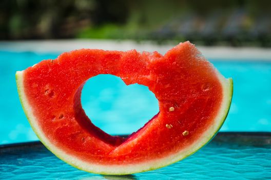Watermelon with Heart shape by the swimming pool - holiday concept