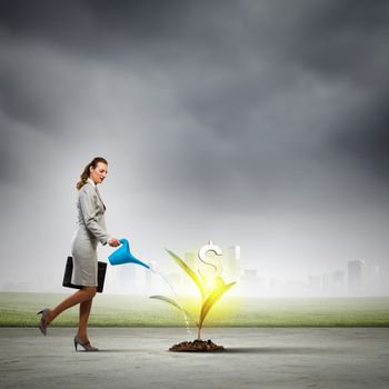 Image of business woman watering money tree. Currency concept