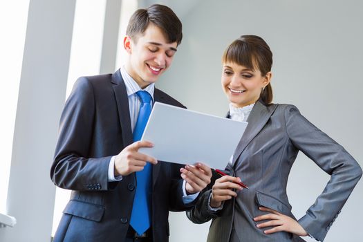 Young happy businessman and businesswoman people discussing project