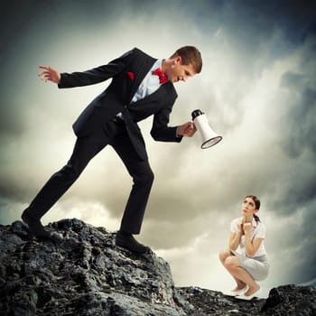 Angry businessman with megaphone shouting at colleague