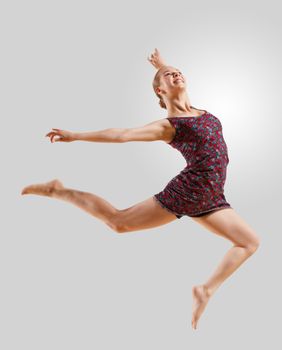 Girl dancing in a color dress with a gray background. isolate