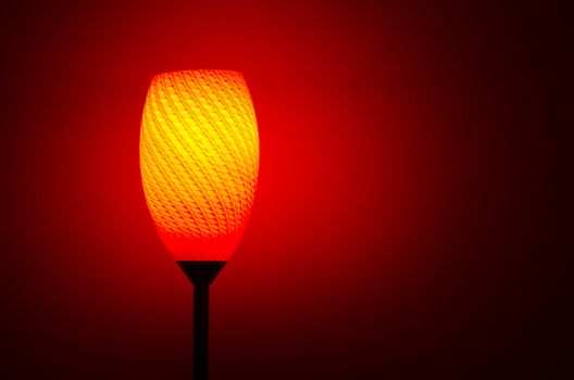 lamp shining red and orange color light with red wall in the background