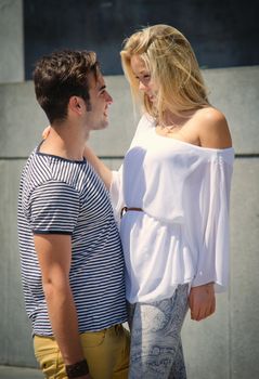 Romantic couple looking in each other's eyes smiling outdoors