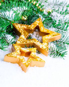 Golden Christmas stars with pine branch and snow