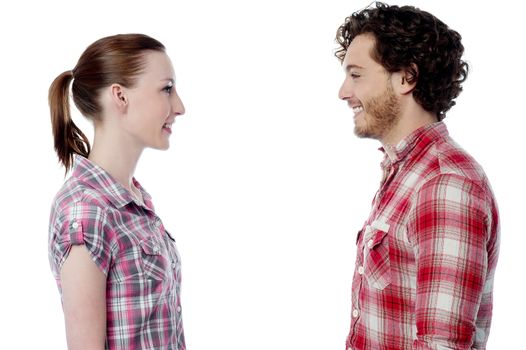 Love couple standing face to face, studio shot.