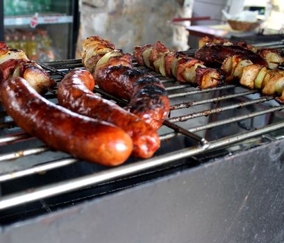 Cooking kebab and sausage on a barbecue grill