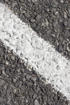 Fragment of asphalt pavement with white strip of road marking