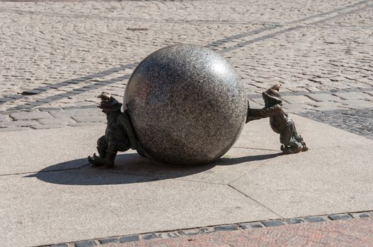 Stone dwarfs with ball on the street.