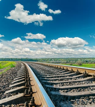 railroad closeup to horizon and deep blue sky with clouds