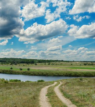 dark clouds over river and dirty road