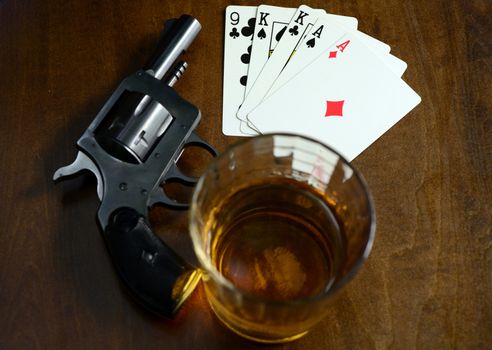 old west poker game with pistol, alcohol and a winning hand