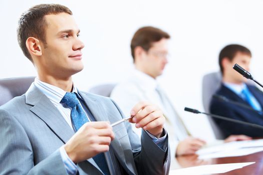 Image of three businesspeople at table at conference