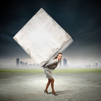 Image of businesswoman carrying big white cube on her back. Place for text