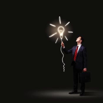 Image of businessman in black suit against dark background