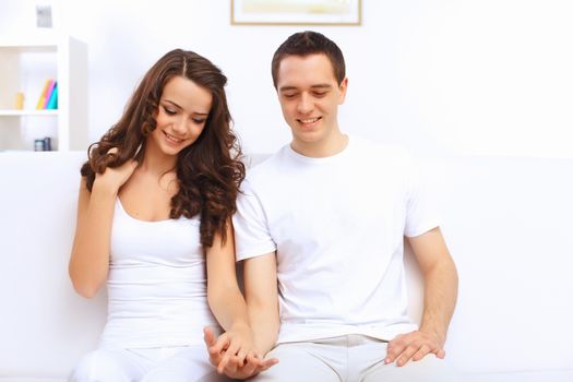 Young happy couple at hone together sitting and talking