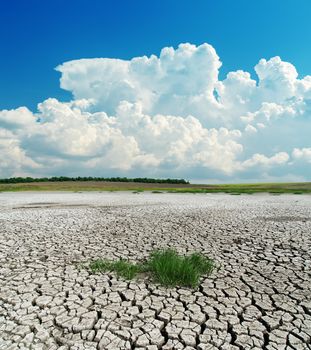 drought earth with green grass under clouds