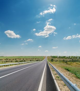 asphalt road closeup under cloudy blue sky