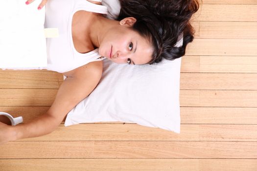 A young adult woman relaxing after reading a book.