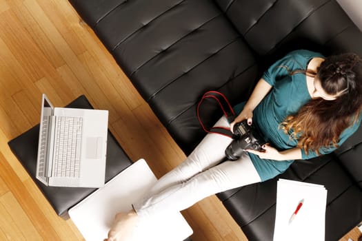 A young latin woman editing Photos on a digital camera.