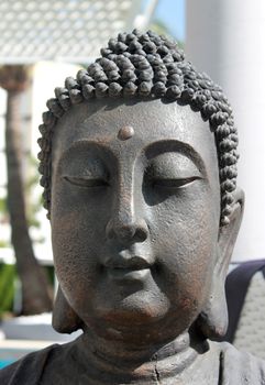 Face of Buddha on statue outdoors.