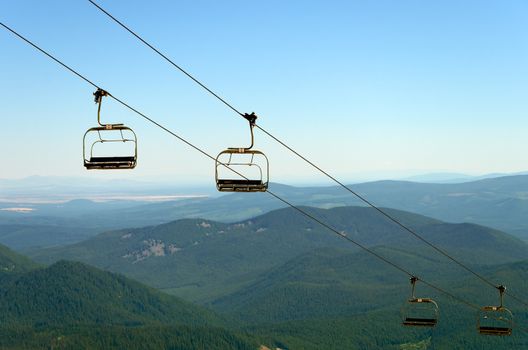 Chairlift on Mount Hood with green pine tree covered hills in the background