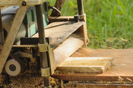 Machine planning a piece of wood in site work.