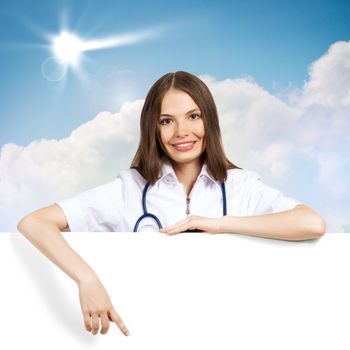 Young attractive female doctor put her hands on the blank banner, points at a place for text