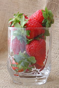 strawberry in a glass over woven fabric