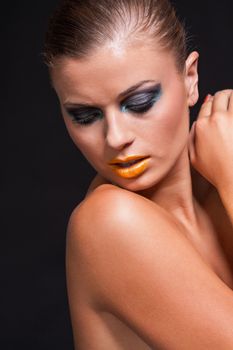 woman with extreme colorfull make up in blue and yellow on black background